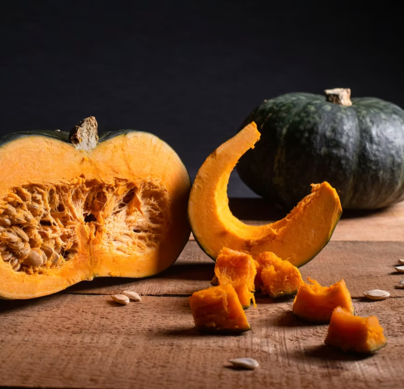 Zuccuri kabocha squash with rich orange flesh and green rind, shown whole and cut into wedges and cubes — a Japanese winter squash featured in the Asian vegetable box.
